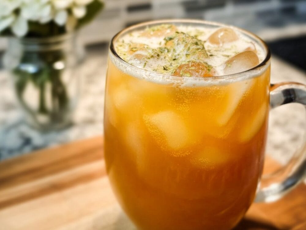 A delicious glass of Anti-Inflammatory Iced Turmeric Green Tea garnished with mint and lemon.