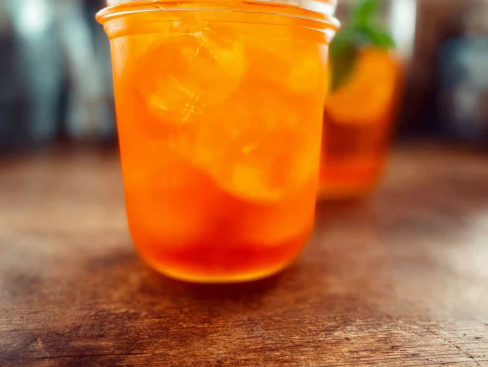 Refreshing Mango Iced Tea served with ice and fresh fruit slices, a perfect summer drink. Enjoy Mango Iced Tea!