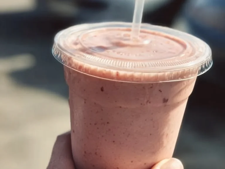 Delicious strawberry protein smoothie in a glass topped with fresh strawberries
