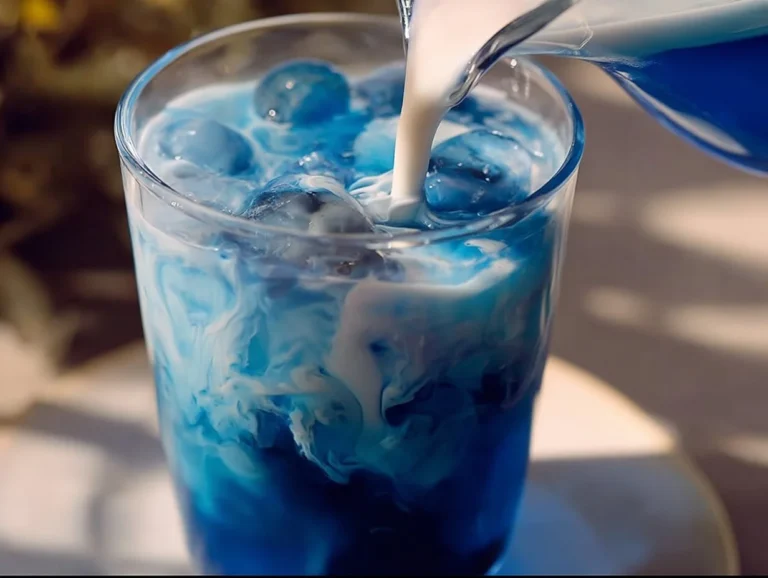 Cup of vibrant blue Butterfly Pea Tea with fresh ingredients