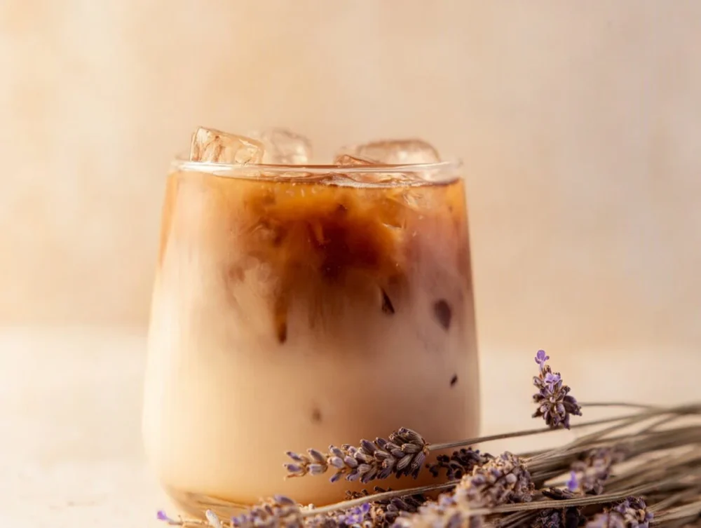 Iced Lavender Oatmilk Latte in a glass with lavender sprigs