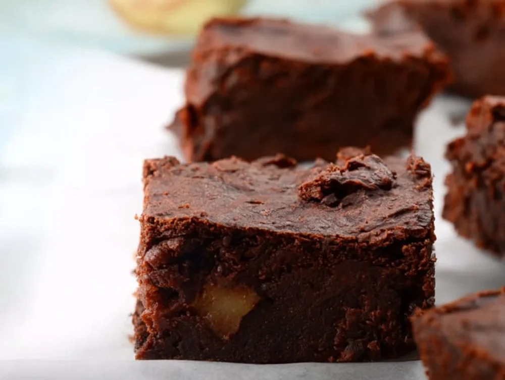A plate of sugar free brownies with apples displayed on a table