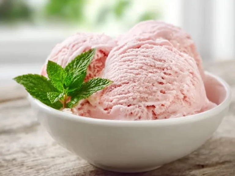 Homemade rhubarb ice cream in a bowl with fresh rhubarb stalks
